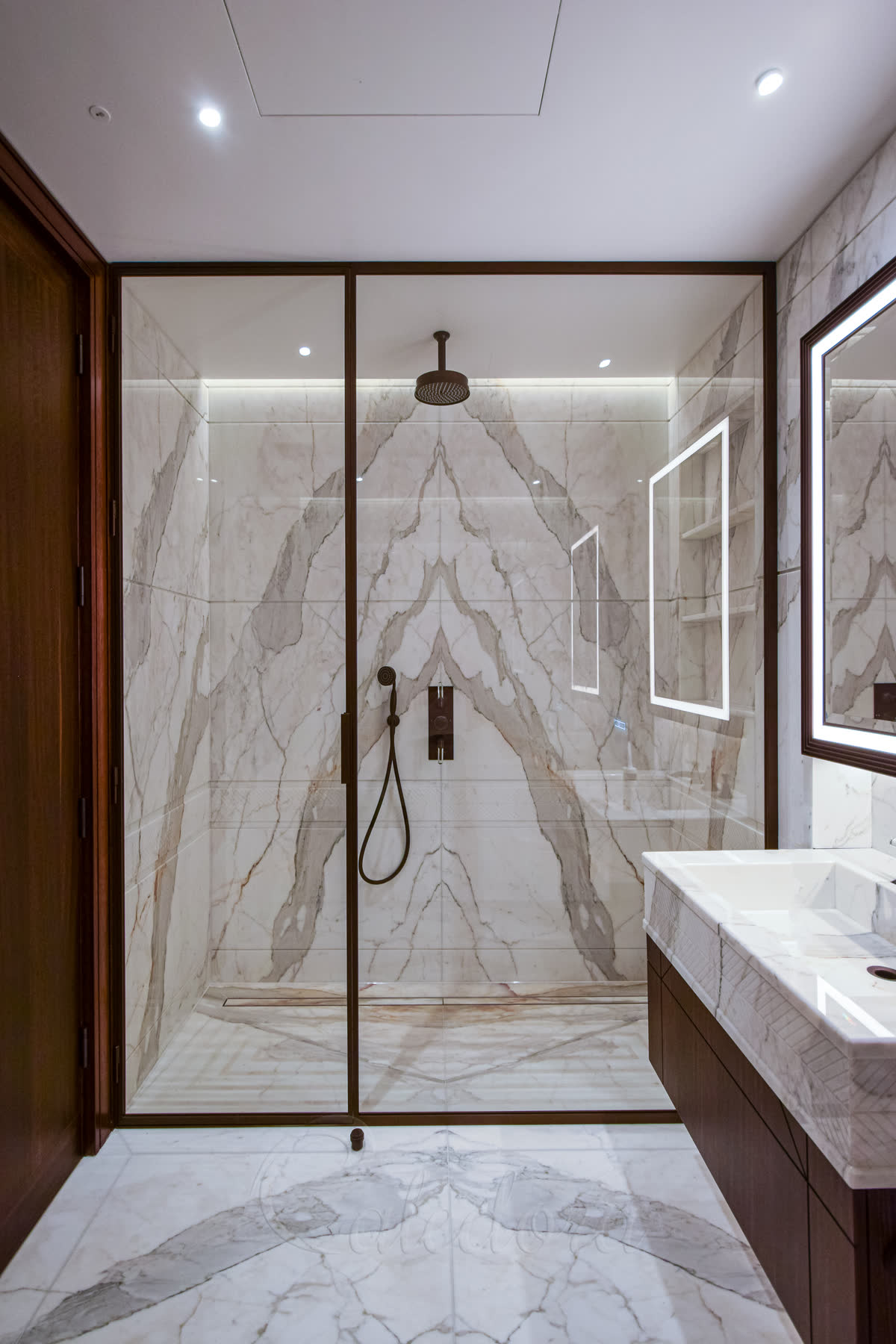 Elegant frameless glass shower with marble surround